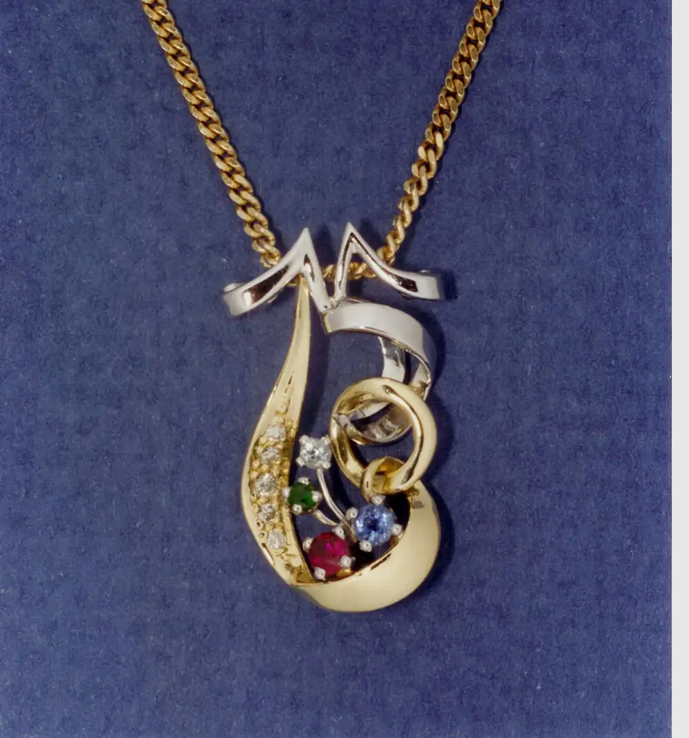 A custom pendant marking a 35th wedding anniversary and a 60th birthday, in platinum and gold, set with the family’s birthstones